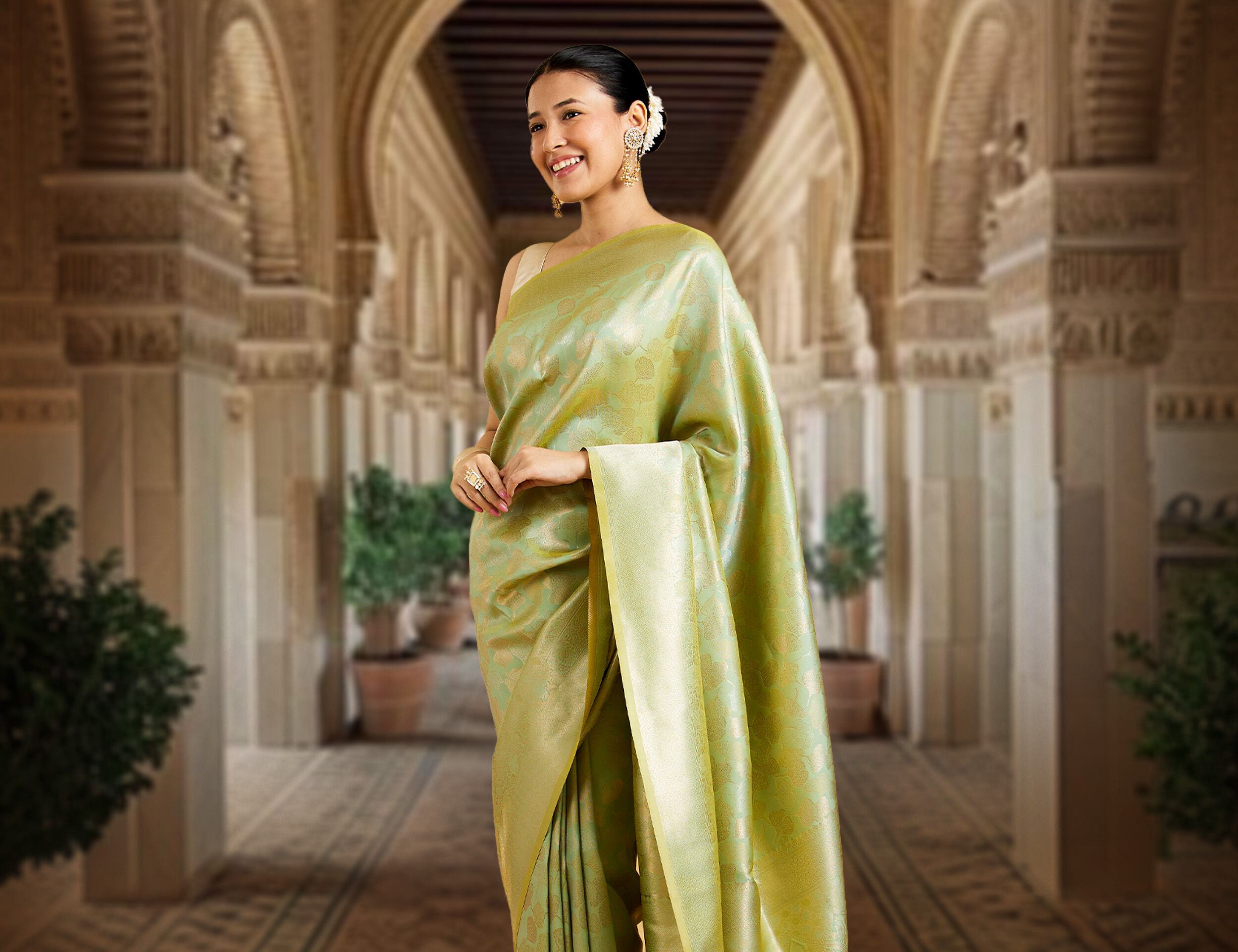 A woman wearing a zari work green saree with jewellery